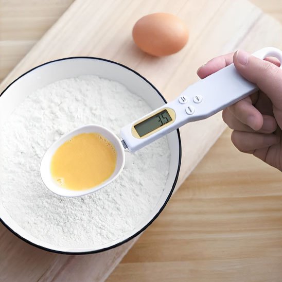 Cuillère doseuse mesure jaune d'oeuf au dessus de bol de farine