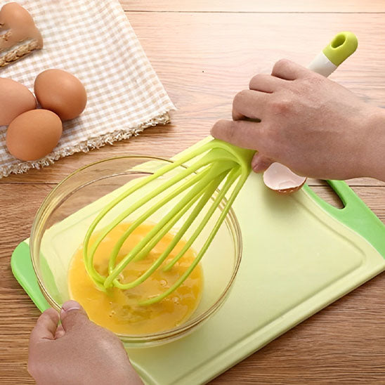 mains-mélange-oeufs-avec-fouet-ballon-vert