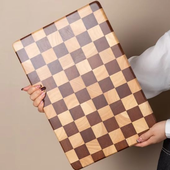 femme tenant grande planche à découper damier