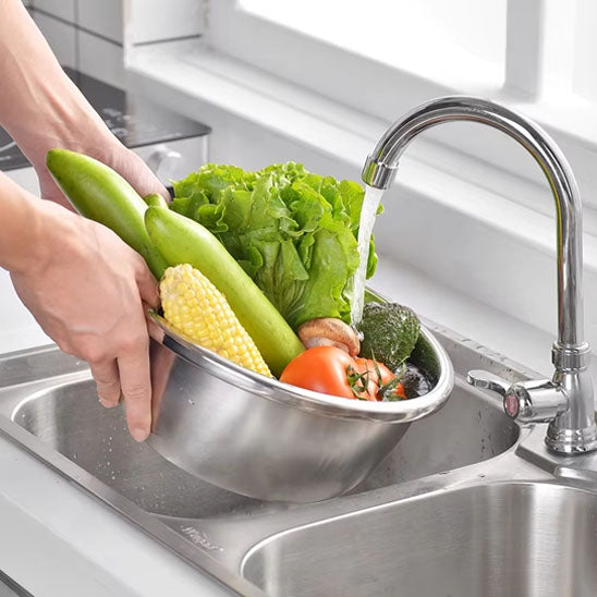 cuisinière-lave-légumes-dans-bassin-d-une-passoire-inox