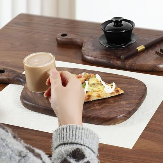 femme-prend-collation-sur-planche-a-decouper-bois-noyer