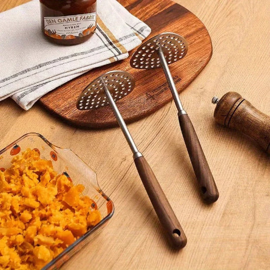 Presse-purée sur comptoir cuisine à coté de plat de pommes de terre douces