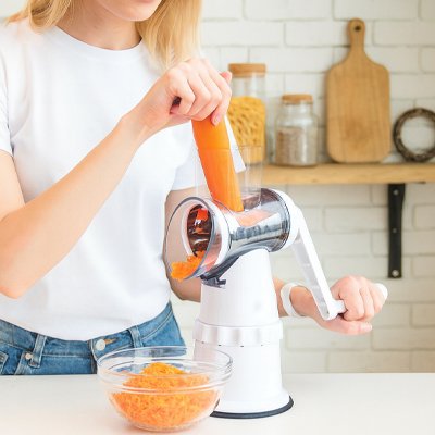 femme ràpe carottes avec râpe à légumes manuelle