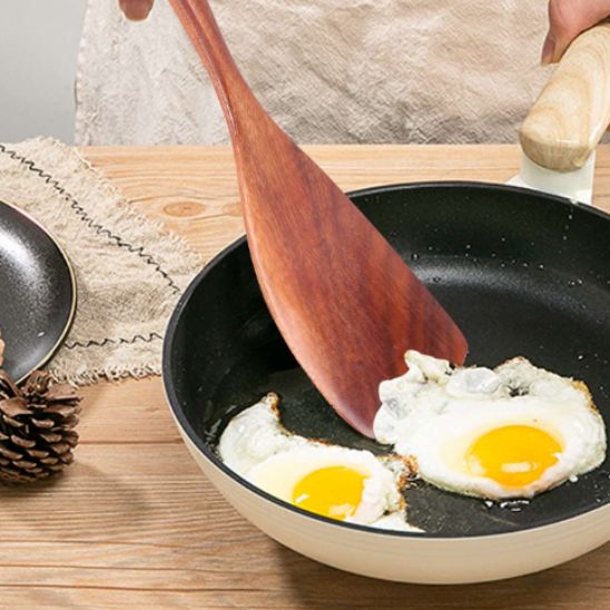 quelqu-un-cuit-oeufs-dans-poêle-avec-spatule-en-bois