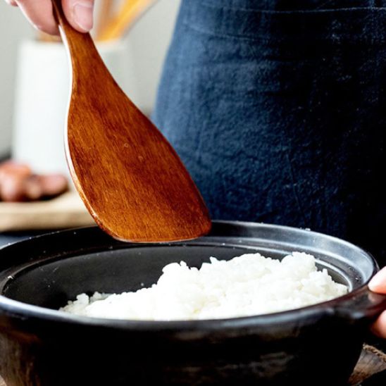 homme-sert-riz-dans-une-marmite-avec-spatule-en-bois