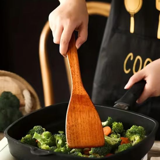 une-personne-mélange-salade-avec-spatule-en-bois