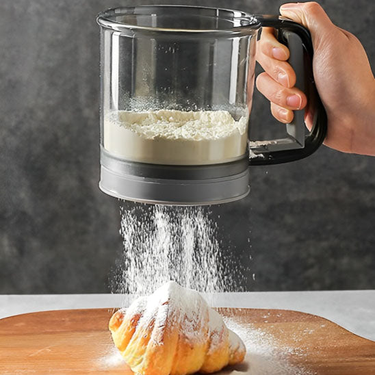 patissière-saupoudre-patisserie-avec-tamis-a-manivelle