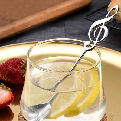 Cuillère à café clé de sol argent dans verre limonade avec tranches citron