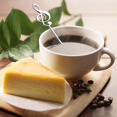 Cuillère à café clé de sol dans tasse café auprès de gâteau