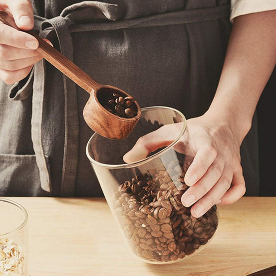 barista ramasse café d'un bocal avec cuillère à café