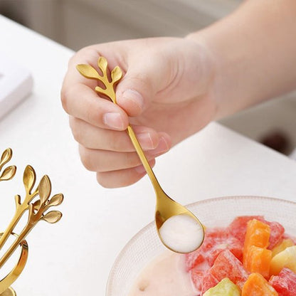 Main d'enfant tient cuillère à café motif feuille