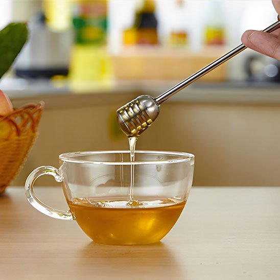 Cuillère à miel inox dégoulinante de miel