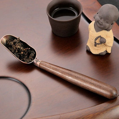 Cuillère à thé de fueilles de thé sur plat de service avec petit boudha