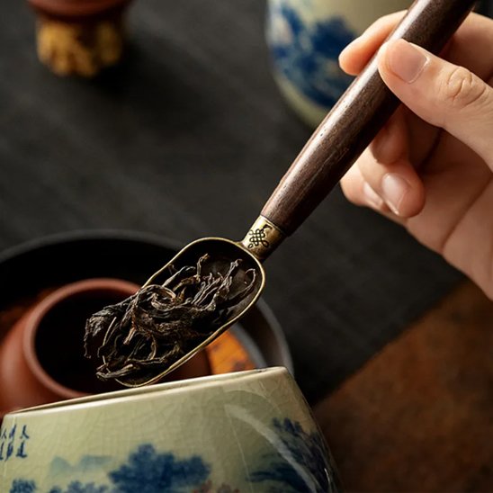 Cuillère à thé de feuilles thé suspendue au-dessus tasse