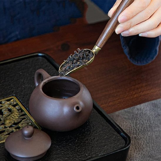 Cuillère à thé gongfu met  feuilles de thé dans théière