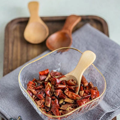 Cuillère en bois dans bol de piments forts