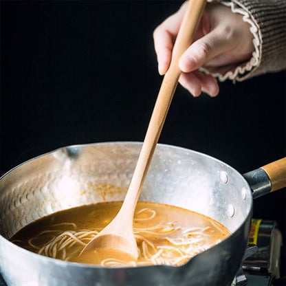 Cuillère en bois mélange soup dans pot aluminium