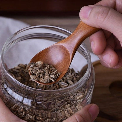 Mini cuillère en bois prélève épices dans pot en verre