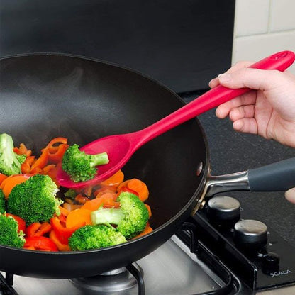 Cuillère en silicone remue légumes sautés dans poêle