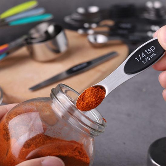 cuillères doseuses contenant paprika à l'ouverture de pot à épices