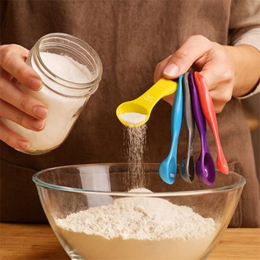 Cuisinier ajoute farine au bol avec cuillères doseuses jaune