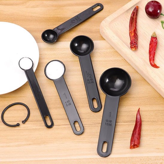 lot de cuillère doseuse plastique sur cointoir cuisine bois