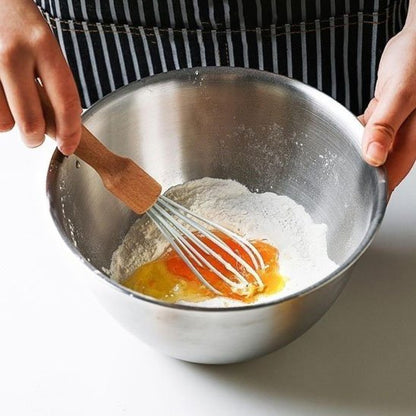 Cuisinier mélange pâtes dans cul de poule inox