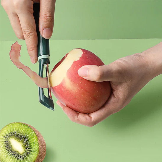 femme-pèle-une-pomme-sur-contoir-vert-pâle-avec-économe
