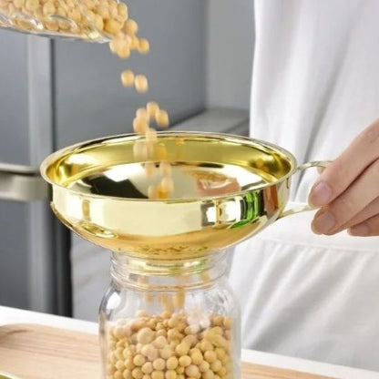 femme transvase haricots secs dans bocal utilisant entonnoir à confiture doré