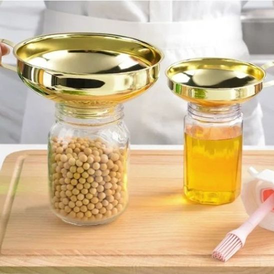 grand entonnoir à confiture doré et petit placés sur bocaux