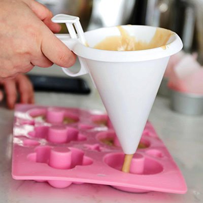 pâte versée dans moule à beignets avec entonnoir à piston conique