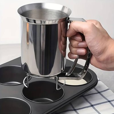 pâte versée dans moule à muffins avec entonnoir à piston inox