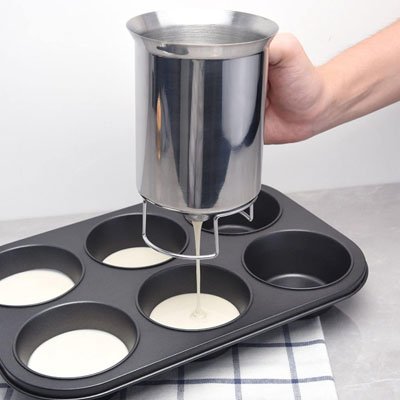 pâte versée dans moule à muffins avec entonnoir à piston inox