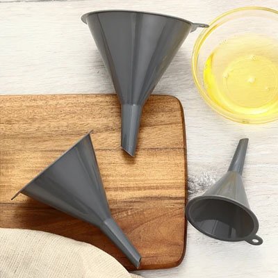set entonnoir en trois grandeurs étalés sure planche à découper