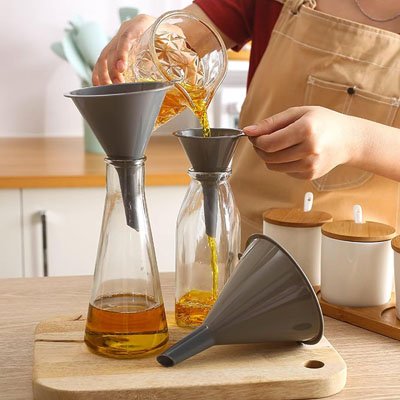 cuisinier transverse huile d'un bocal a une bouteille avec entonnoir plastique