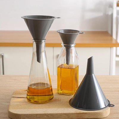 Entonnoir plastique gris en trois grandeurs placés dans bouteille sur comptoir