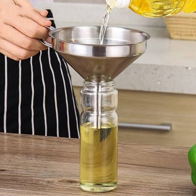 cuisinier utilise anse latérale pour tenir  entonnoir inox