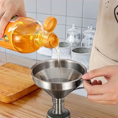 femme verse huile dans bouteille avec entonnoir inox