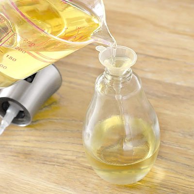 huile versée avec précision dans petite bouteill avec entonnoir miniature