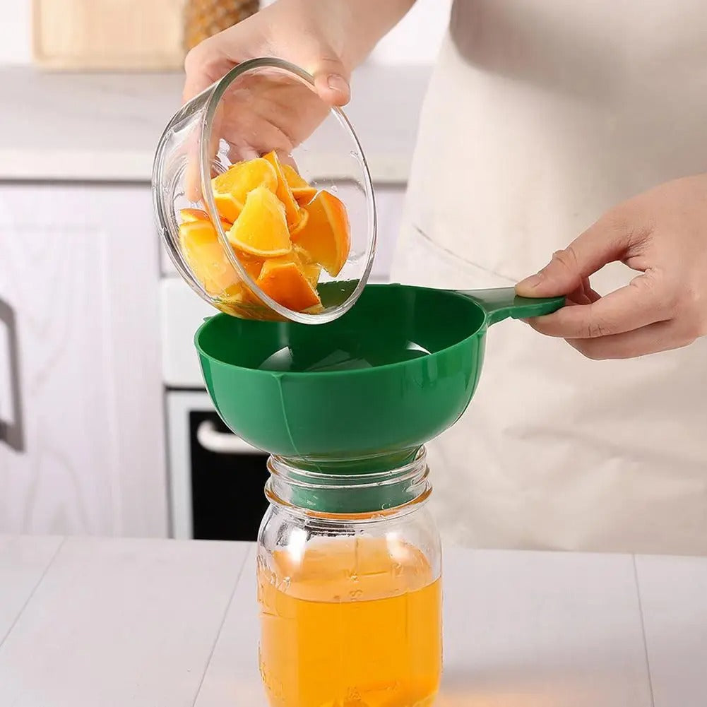 cuisinière transvase oranges coupées utilisant entonnoir pour bocaux vert
