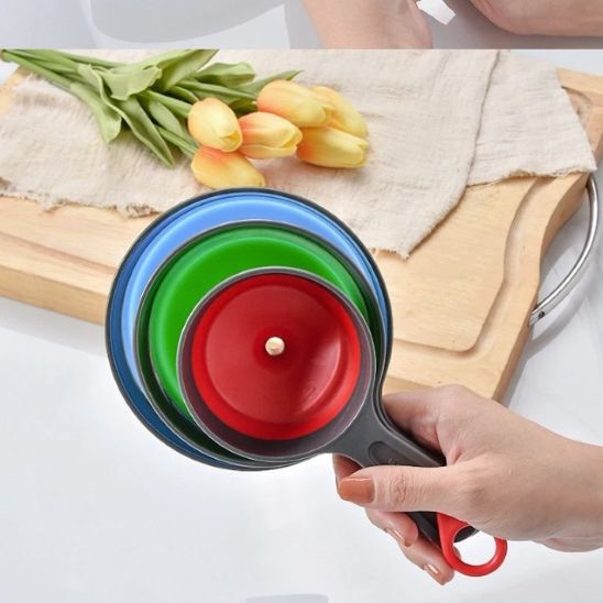 femme tient trois grandeurs d'entoinoir pliable emboîtés