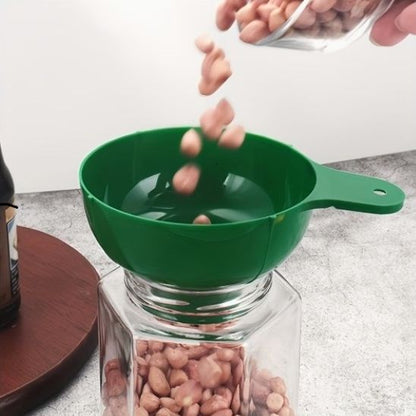 noix tombent dans bocal à travers entonnoir vert