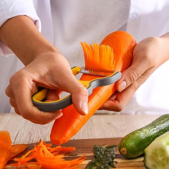 femme-julienne-une-carotte-avec-un-éplucheur-jaune