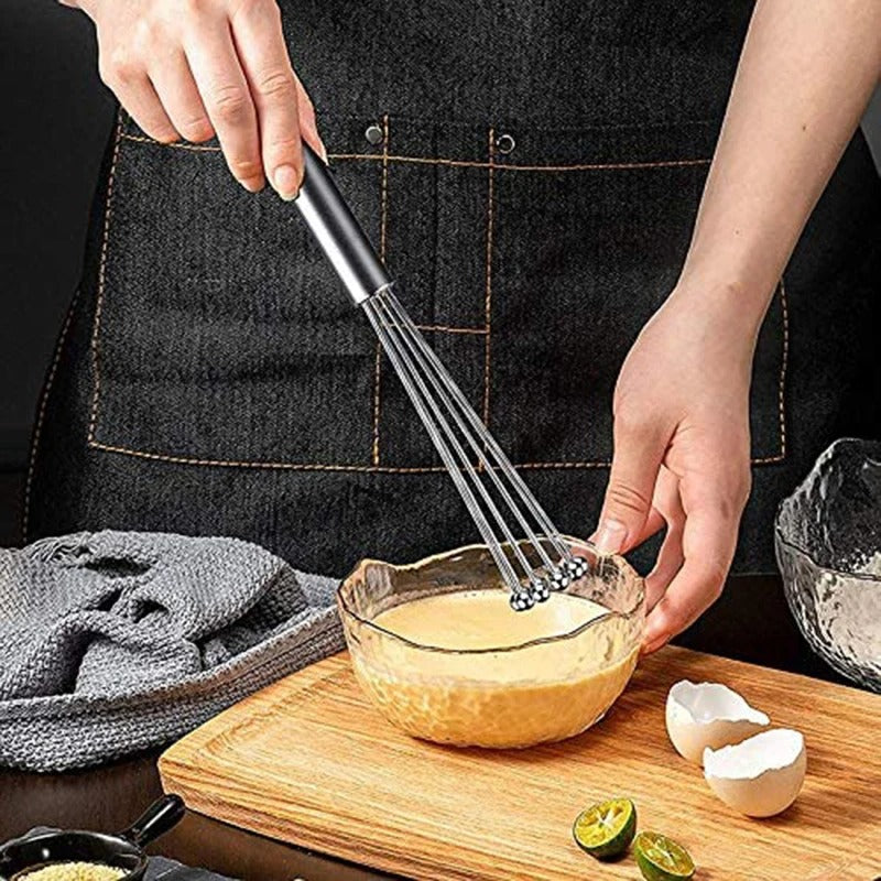 femme bat oeufs avec fouet cuisine billes