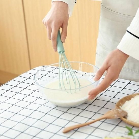 cuisinier fouette blancs d'œufs dans bol avec fouet cuisine