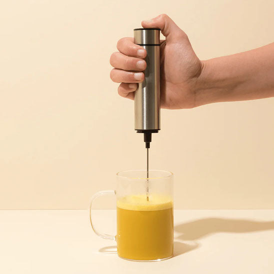 homme mousse cappuccino avec fouet mousseur électrique