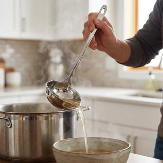 homme verse bouillon dans  bol posé sur comptoir avec une louche inox