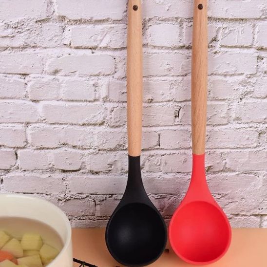louche noir et louche rouge appuyées contre un mur