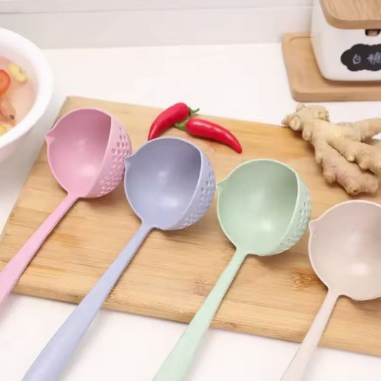 quatre louches passoire de couleurs différente sure une plance à écouper