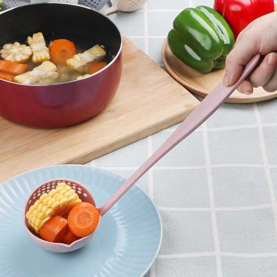 louche passoire rose plaçant légumes sur assiette bleue